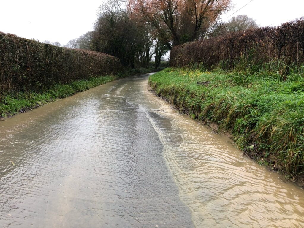 River floods over road